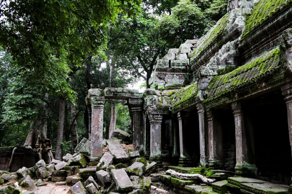 Moss-covered ancient temple ruins in a forest, symbolizing creativity and inspiration emerging during times of collapse and uncertainty.