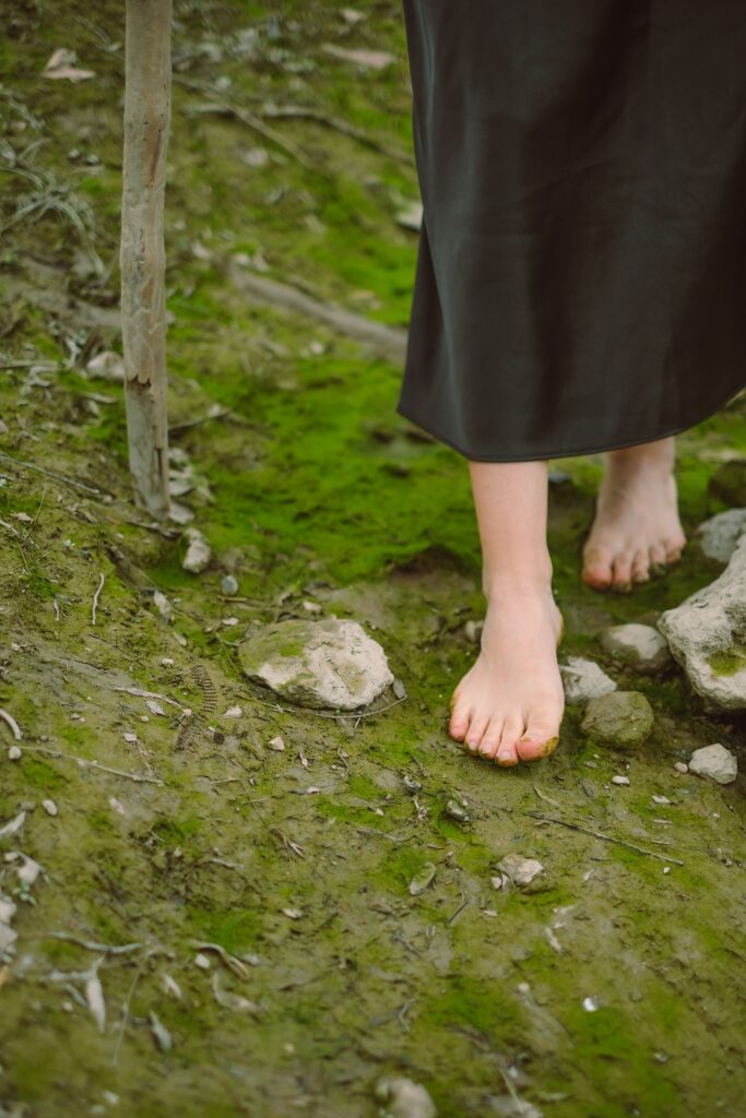 Bare feet walking through moss-covered earth during the New Moon in Virgo